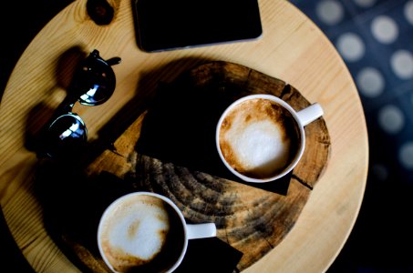 two ceramic cups with cafe latte on wooden table photo