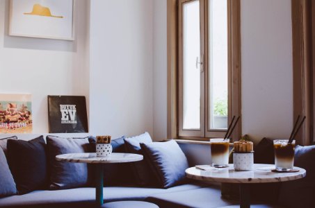 two round wooden framed tables near gray padded sofa photo