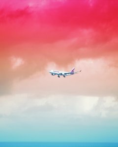 Qatar Airlines airplane flying under red cloud formation photo