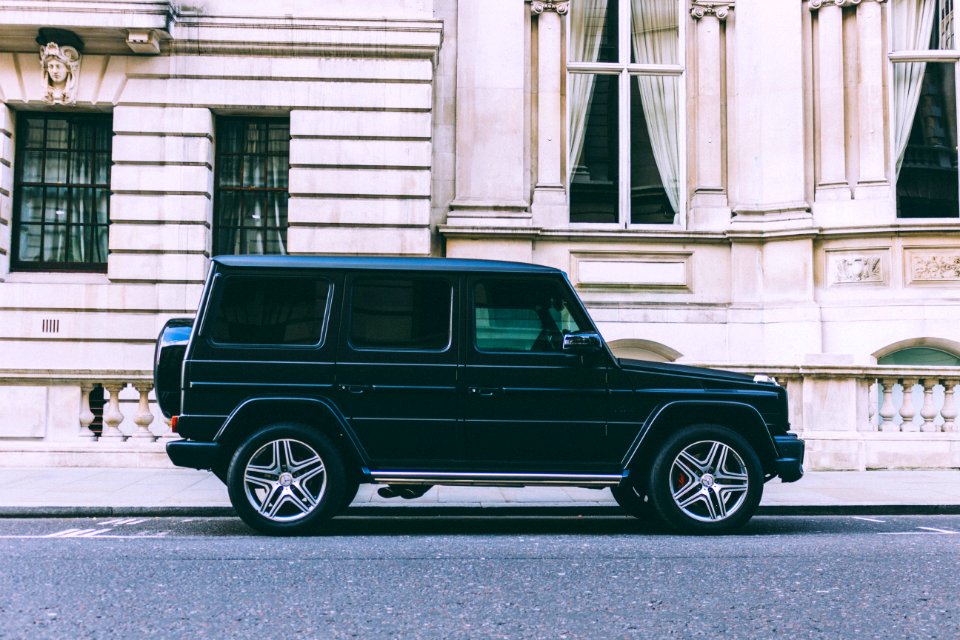 black Mercedes-Benz SUV parked beside white building