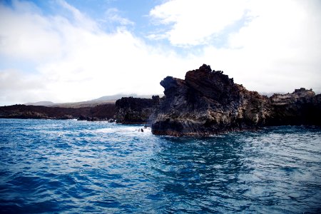 rock in ocean under white sky photo