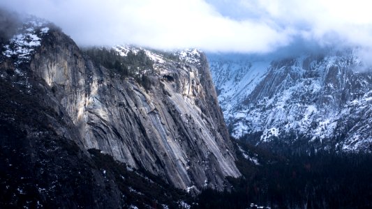 photo of snow capped mountain under white clouds