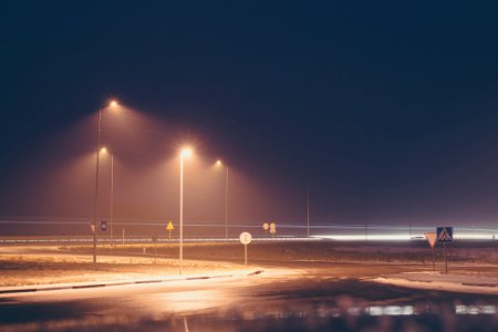 concrete road with turned on post lamp lights at nighttime photo