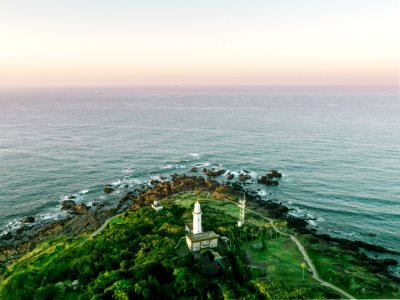 aerial photography of white tower on island near sea under white clouds photo