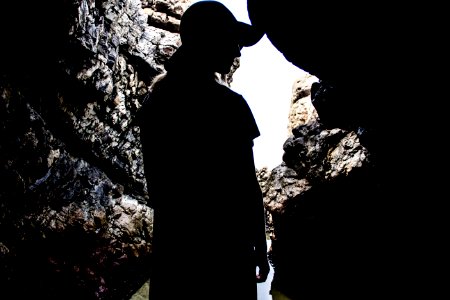 silhouette of woman standing inside cave photo