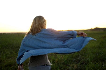 woman walking in the middle of grass field photo