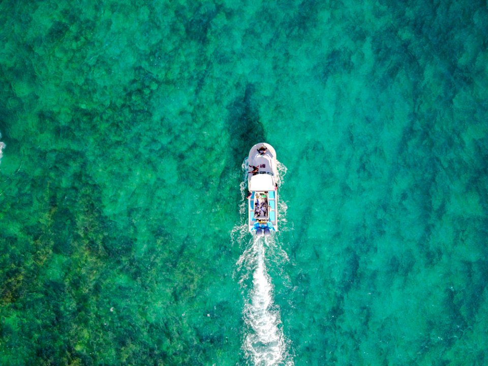 aerial photo of white boat sailing on body of water at daytime