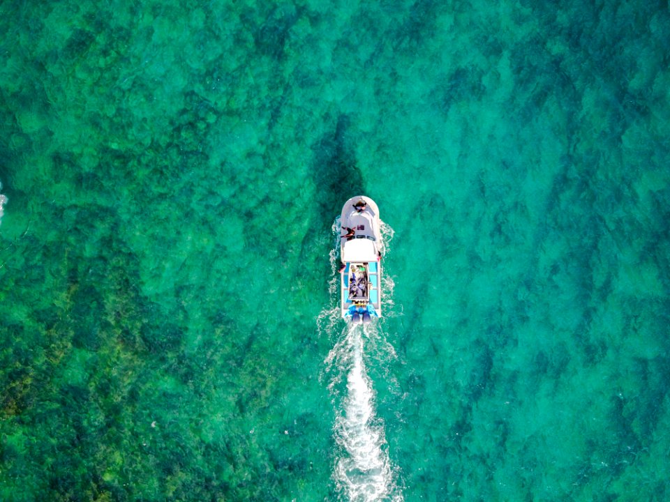 aerial photo of white boat sailing on body of water at daytime photo