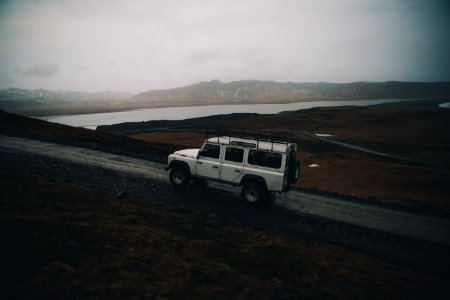 white sport utility vehicle running on road near field photo