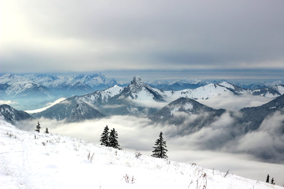 snow covered mountains under grey clouds