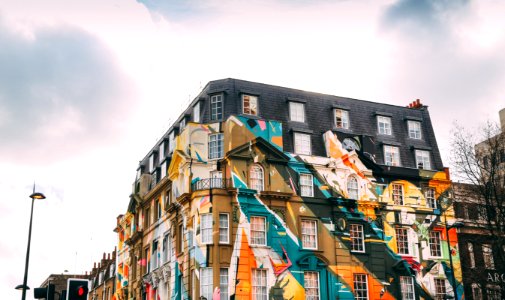 low-angle photography of building with art painting