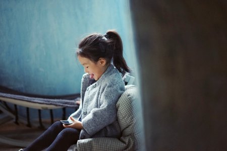 girl sticking her tongue out while using mobile phone