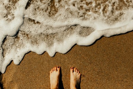 person's feet on seashore photo