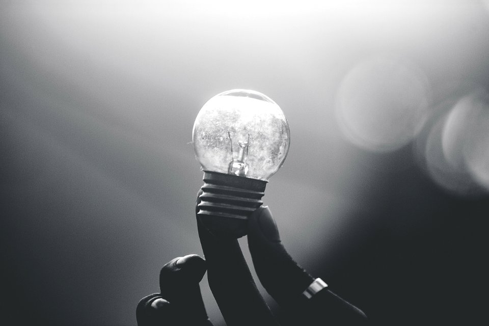 Holding up a small lightbulb.