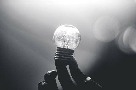 Holding up a small lightbulb.