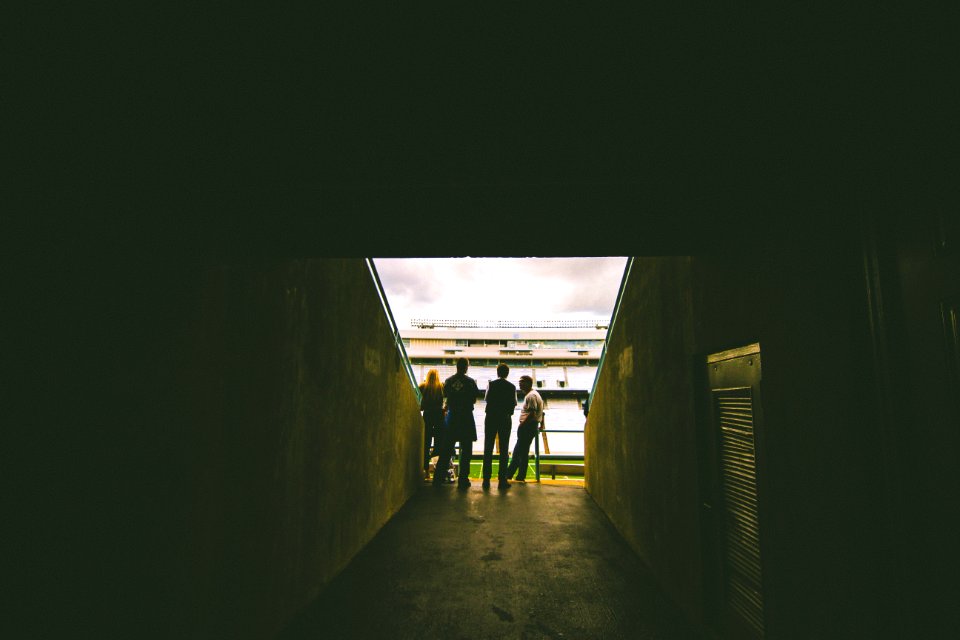 four people standing near gray concrete wall during daytie