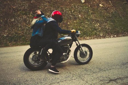 man and woman riding on cruiser motorcycle at blacktop road photo