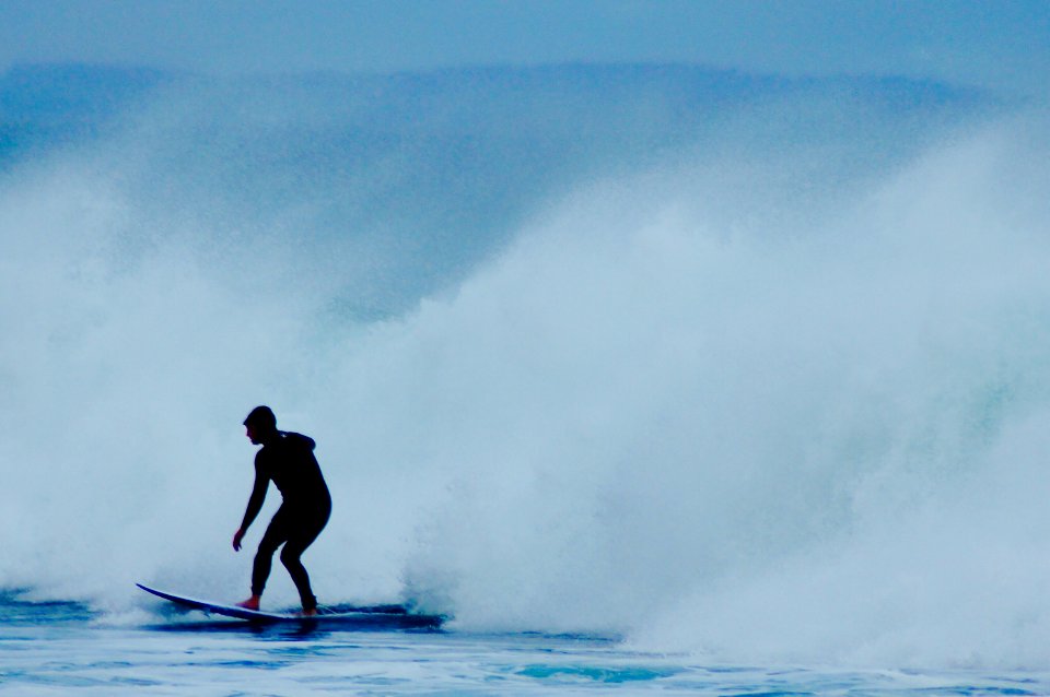 man riding surfboard near wave