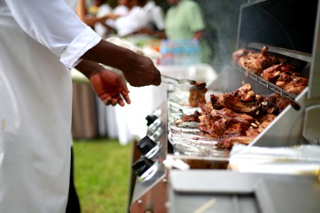 person in white shirt grilling meat photo