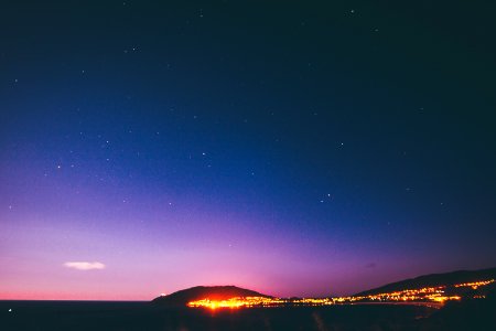 silhouette of buildings and mountain under blue and purple skies photo
