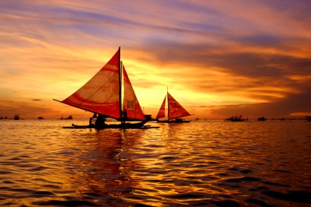 silhouette of sail boats floating on body of water photo