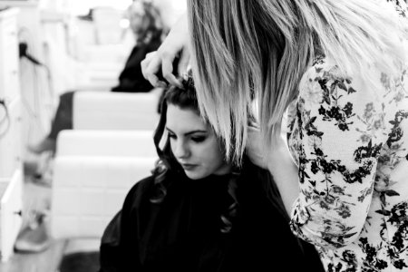 grayscale photography of woman getting her hair done inside salon photo