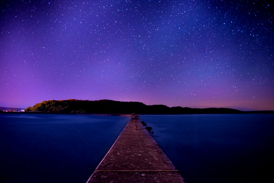 brown wooden dock under night sky
