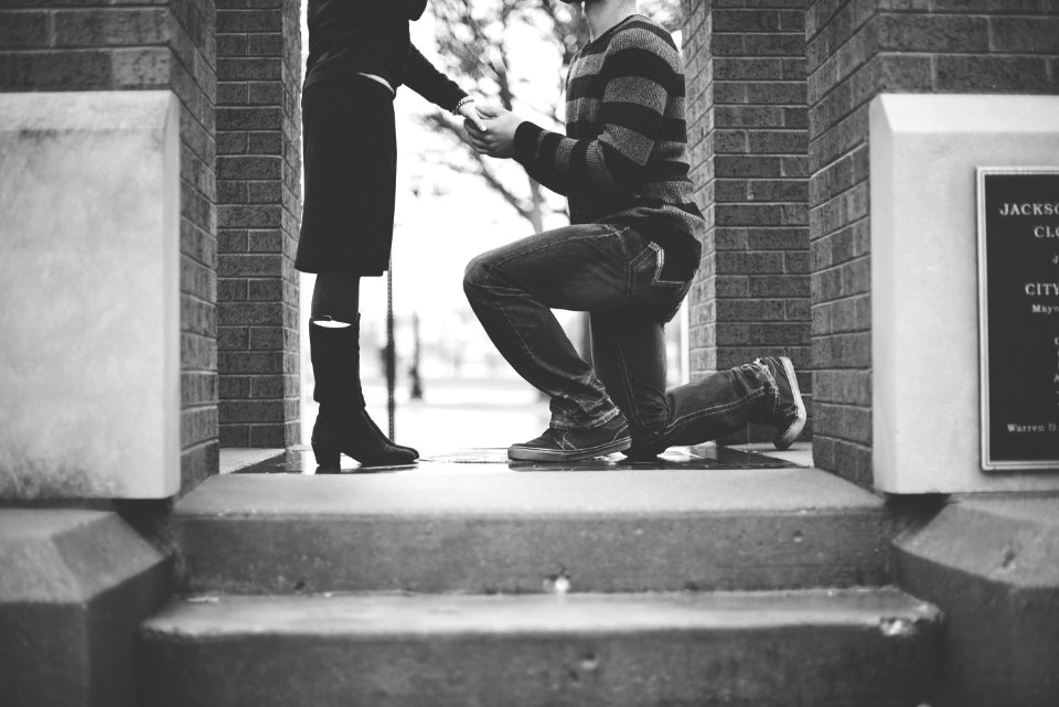 man kneeling in front of woman