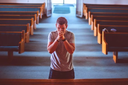 man standing near altar praying photo
