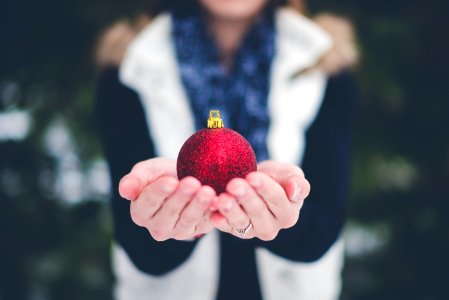 shallow focus photography of person holding bauble photo