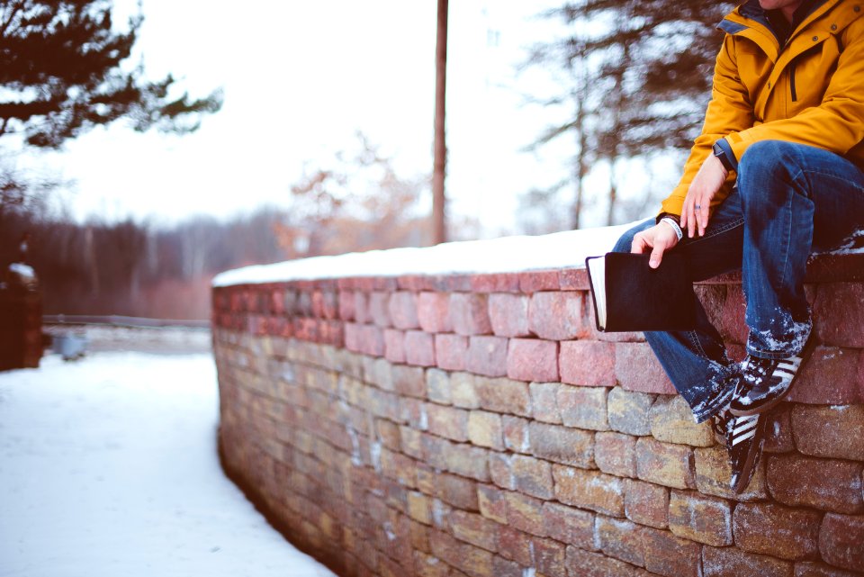 person sitting on brick wall