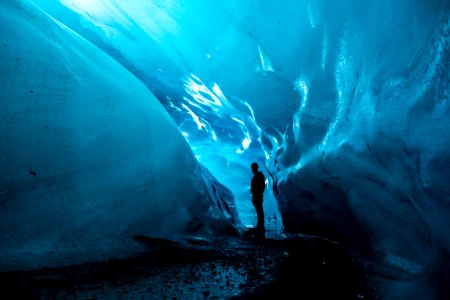 person standing in ice cave at daytime