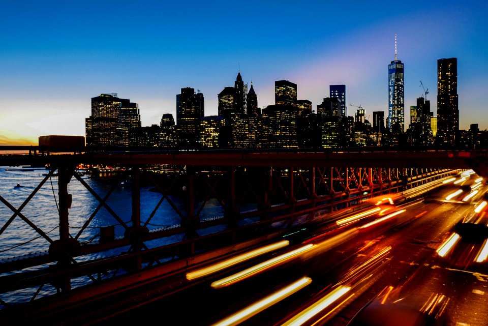 A long-exposure shot of light trails on the freeway with the New York city skyline at the back photo