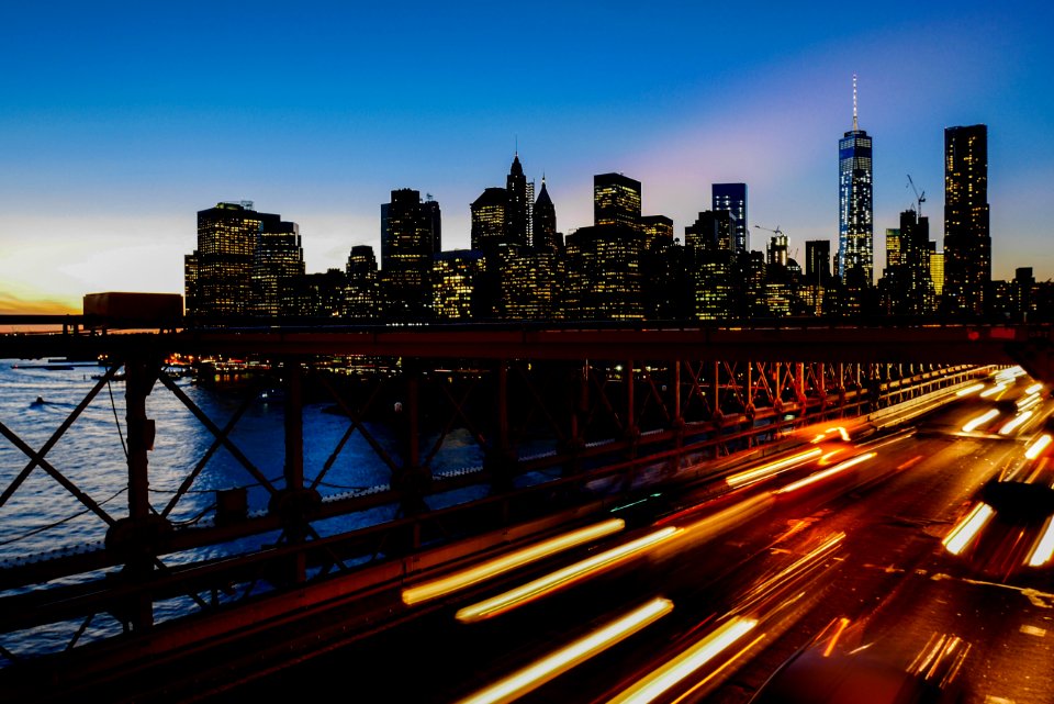 A long-exposure shot of light trails on the freeway with the New York city skyline at the back