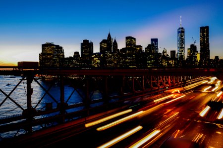 A long-exposure shot of light trails on the freeway with the New York city skyline at the back photo