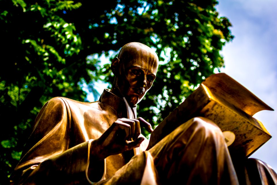 bronze man reading book statue photo