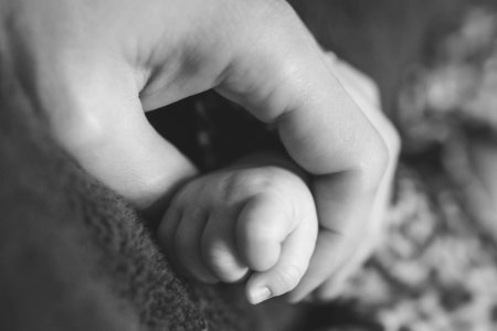 Black and white photo of mother holding child's hand photo
