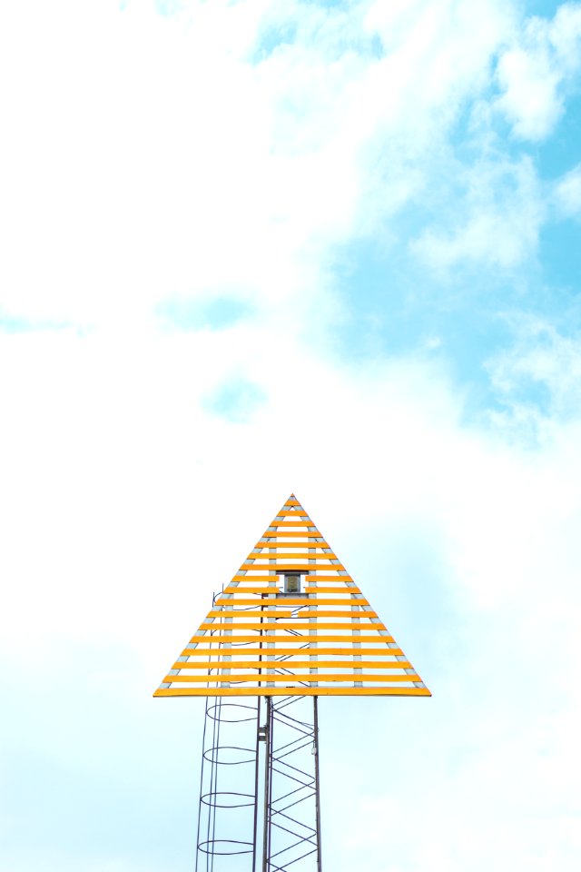 closeup photo of triangle tower with cloudy sky