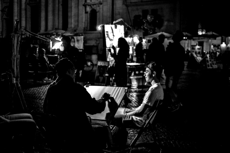 grayscale photography of people at the street near buildings during night