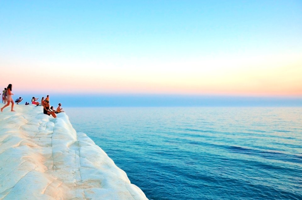 group of people sitting on white limestone