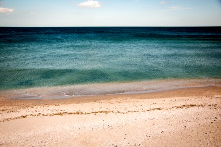 calm water of sea under blue and white sky during daytime photography photo