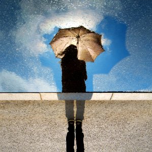 person standing on gray surface while holding umbrella photo