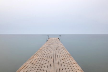 brown wooden dock with cloudy sky photo