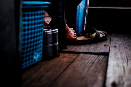 person reaching sandal with his foot