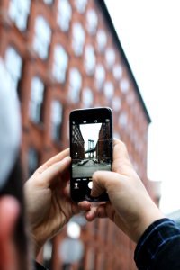 A person taking a picture of urban buildings with their phone. photo