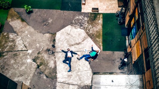 aerial view of two men lying on concrete pavement photo