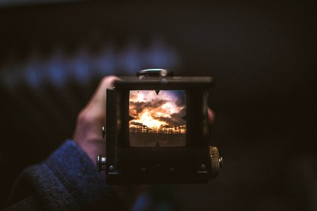 selective focus photography of person holding camera photo