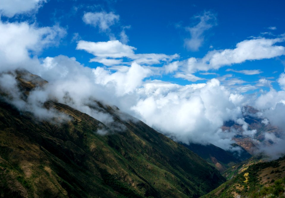 view of mountain covered with green grass and white clouds during daytime photo