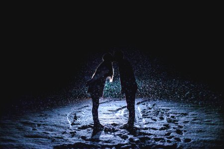 man and woman kissing in the middle of the rain photo