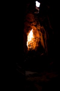person walking inside the cave during daytime